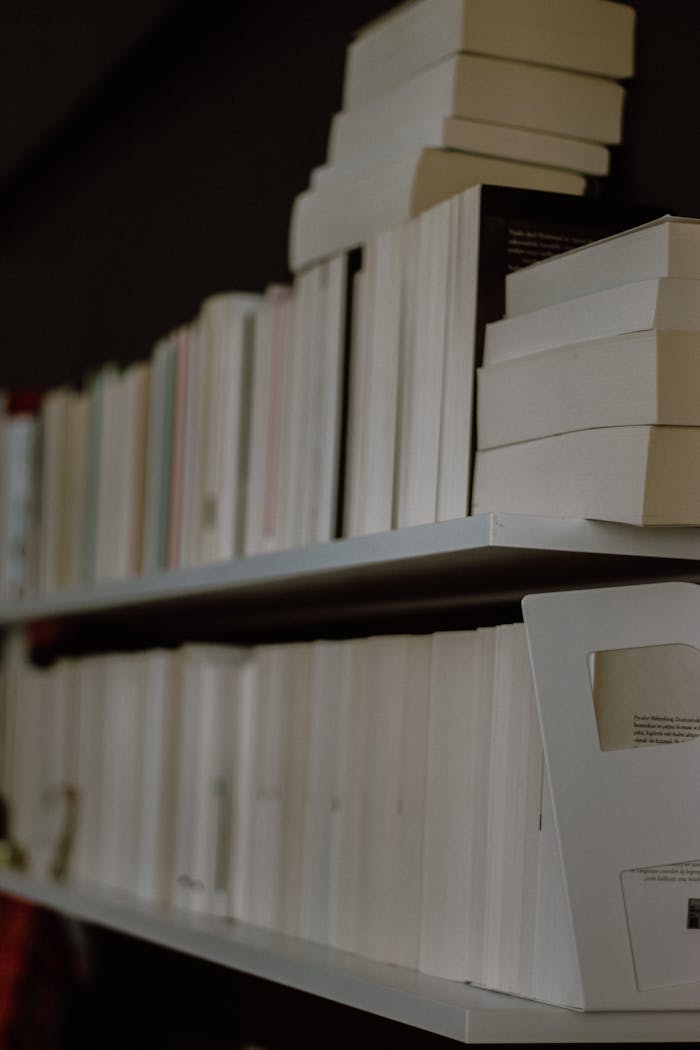 Close-up view of vertically stacked books on a shelf in a modern library setting.