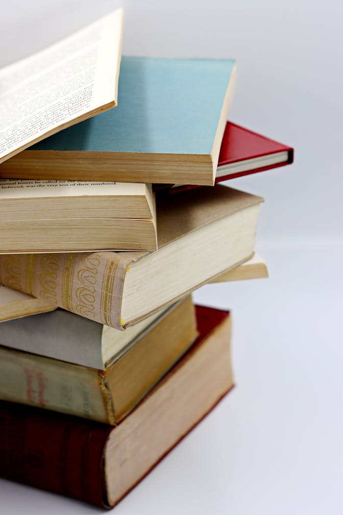 A vertical stack of various hardcover books with visible pages, ideal for literature themes.