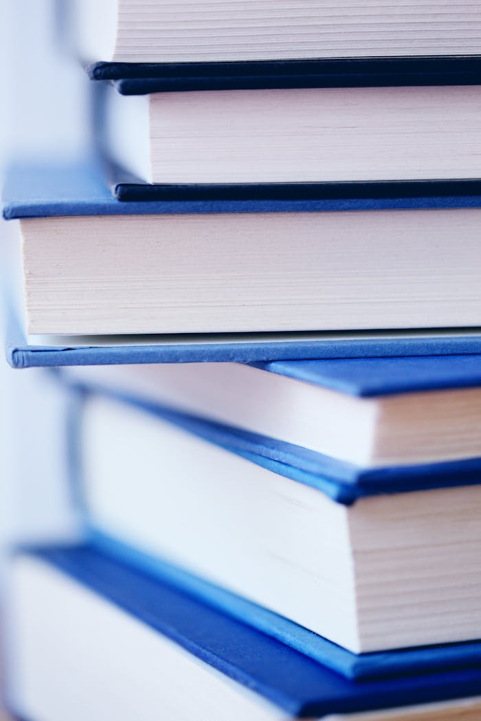 Vertical shot of piled blue hardcover books in close-up detail.